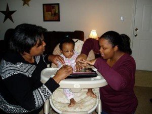 Two Adults Helping Toddler with iPad